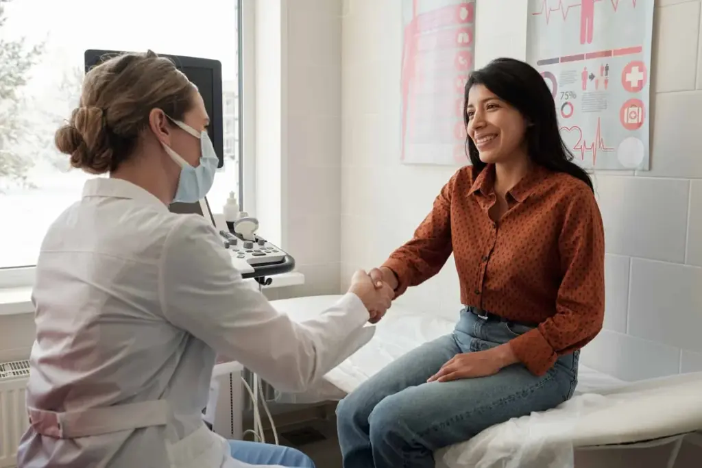 A clinician reviewing notes with a seated patient