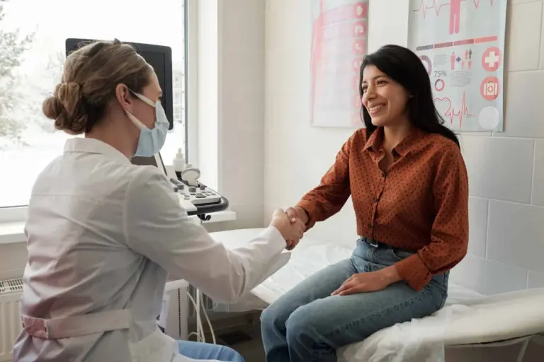 A clinician reviewing notes with a seated patient