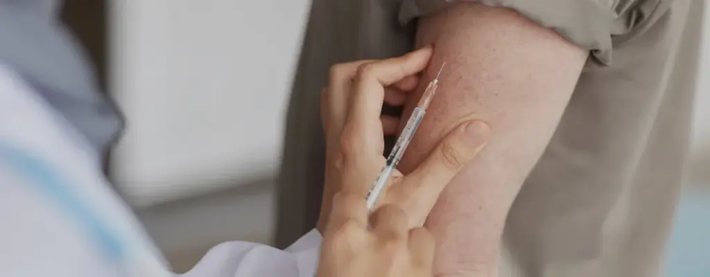 A vial and syringe on a clinical surface